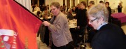 Dame med fane og folk i baggrunden